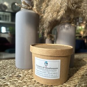 This image is of a brown paper tub with A bone broth based soup for dogs with medicinal mushroom to boost immunity and healing spices.